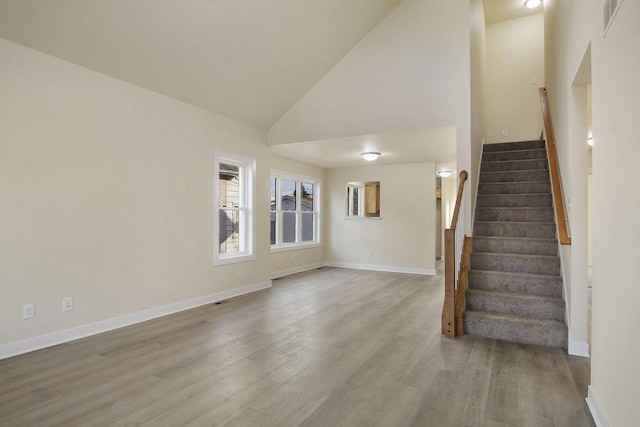 interior space featuring light hardwood / wood-style floors and high vaulted ceiling