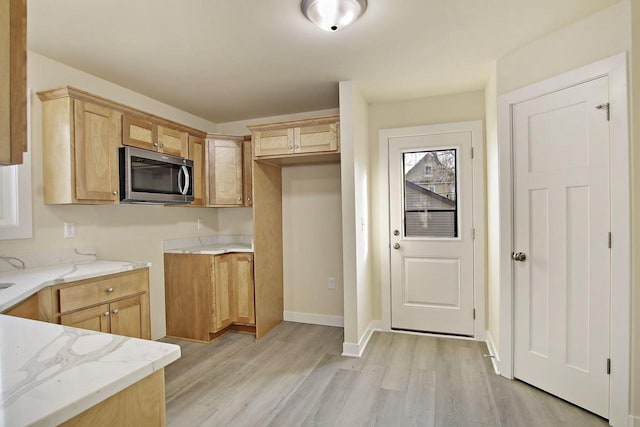 kitchen with light stone counters and light hardwood / wood-style flooring