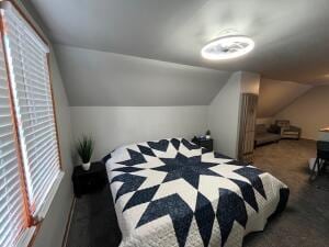 bedroom featuring dark carpet and lofted ceiling