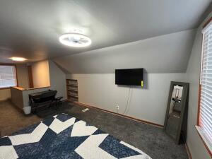 bonus room featuring lofted ceiling and dark colored carpet