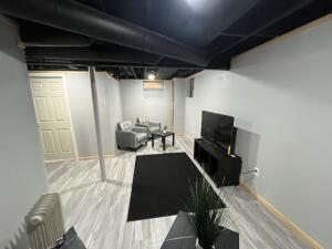 basement featuring hardwood / wood-style floors and radiator heating unit