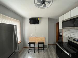 kitchen with ceiling fan, tasteful backsplash, light hardwood / wood-style flooring, white cabinets, and appliances with stainless steel finishes