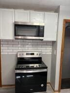 kitchen with appliances with stainless steel finishes and white cabinetry