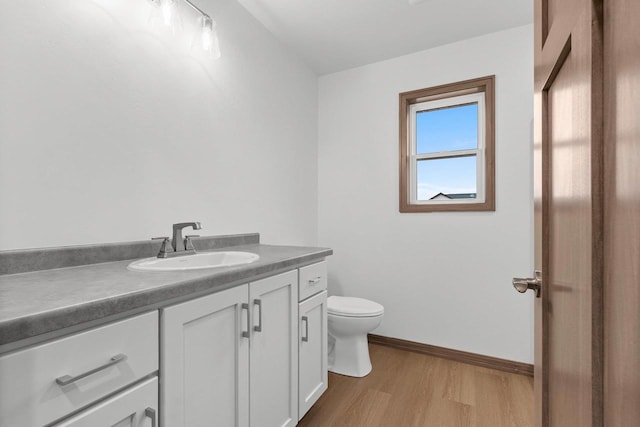 bathroom with hardwood / wood-style floors, vanity, and toilet