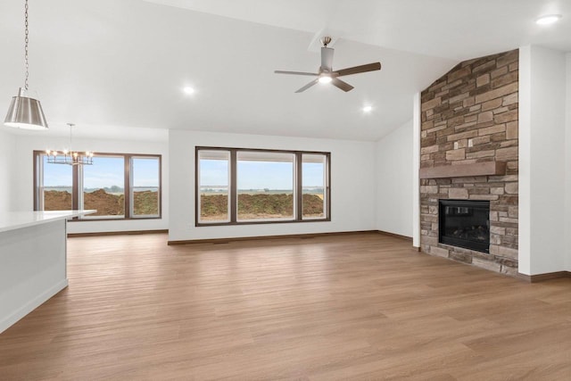 unfurnished living room with a healthy amount of sunlight, vaulted ceiling, and light wood-type flooring