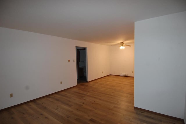 unfurnished room featuring hardwood / wood-style flooring and a baseboard radiator