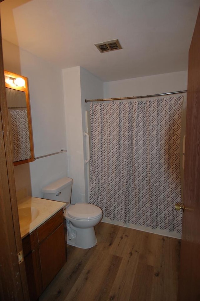 bathroom featuring toilet, vanity, and hardwood / wood-style floors