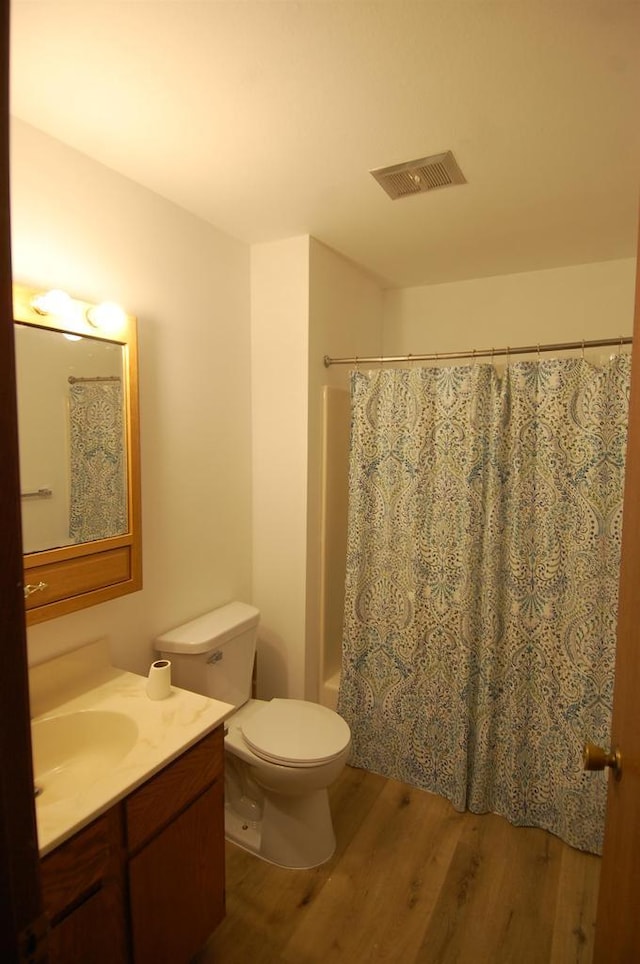 full bathroom with toilet, shower / bath combination with curtain, wood-type flooring, and vanity