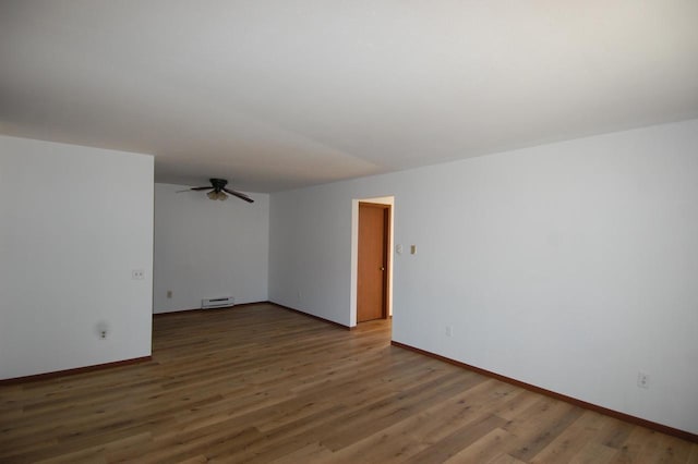 spare room featuring dark hardwood / wood-style flooring, a baseboard heating unit, and ceiling fan