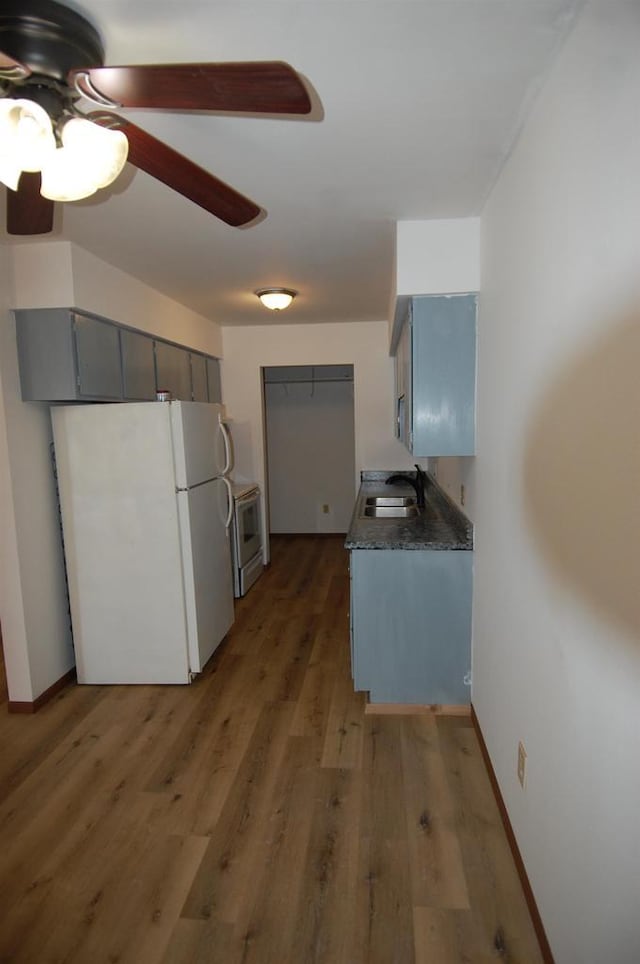 kitchen featuring sink, white appliances, ceiling fan, gray cabinets, and dark wood-type flooring