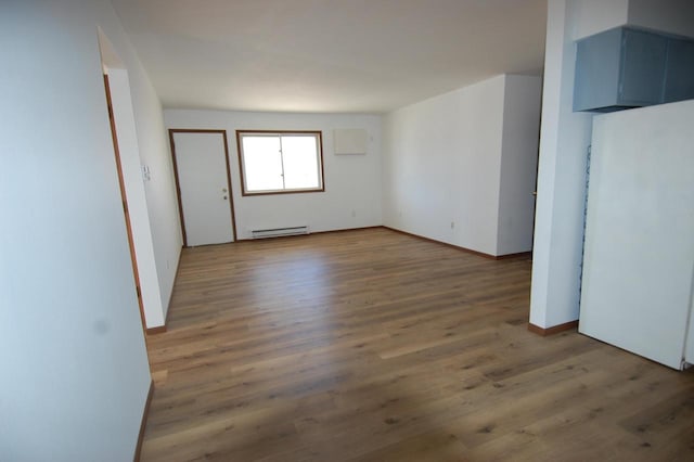 spare room featuring a baseboard radiator and hardwood / wood-style flooring