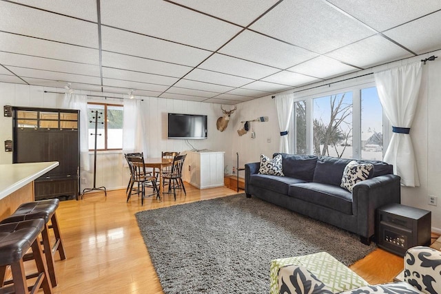 living room with hardwood / wood-style flooring and a drop ceiling