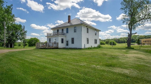 back of property with a lawn, a balcony, and a deck