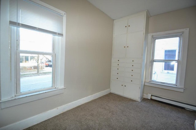 unfurnished bedroom with light colored carpet and a baseboard radiator