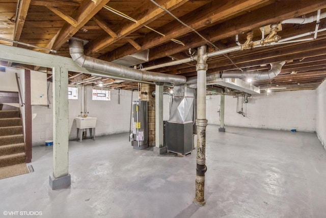 basement featuring gas water heater, heating unit, and sink