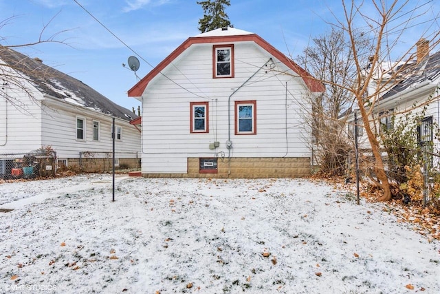 view of snow covered back of property