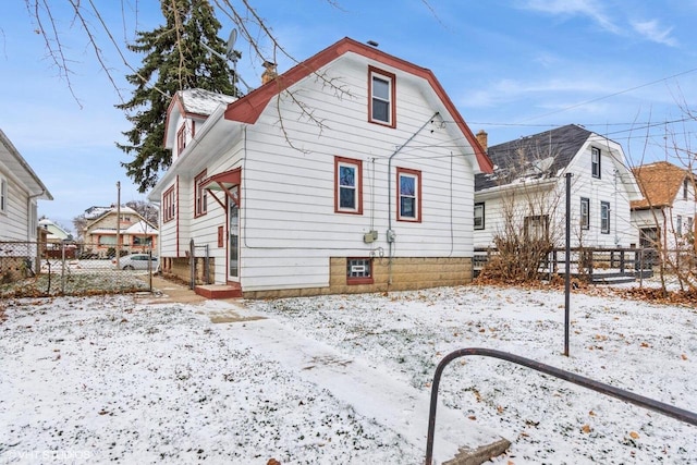 view of snow covered back of property