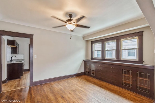 unfurnished room with ceiling fan, sink, and light hardwood / wood-style floors