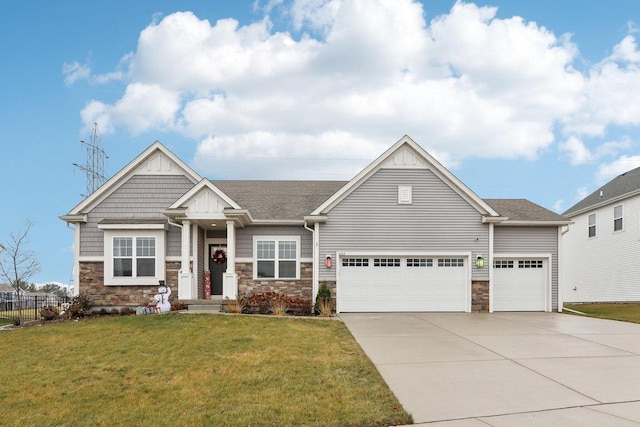 craftsman house featuring a garage and a front lawn