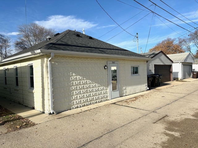 view of property exterior with an outdoor structure and a garage