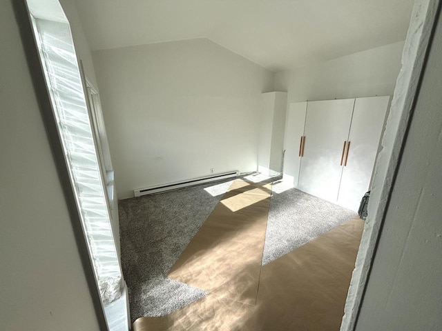 spare room featuring baseboard heating and vaulted ceiling