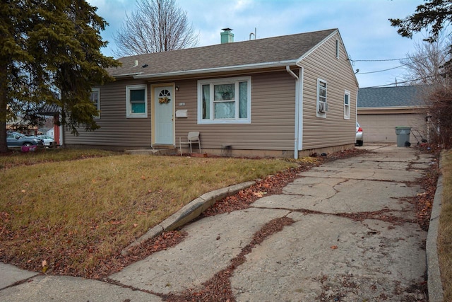 view of front facade with a garage, an outbuilding, and a front yard