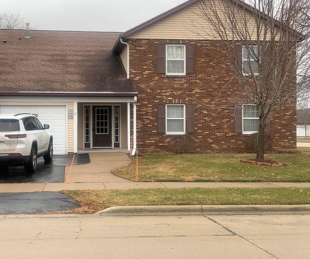 view of front of house featuring a garage and a front lawn