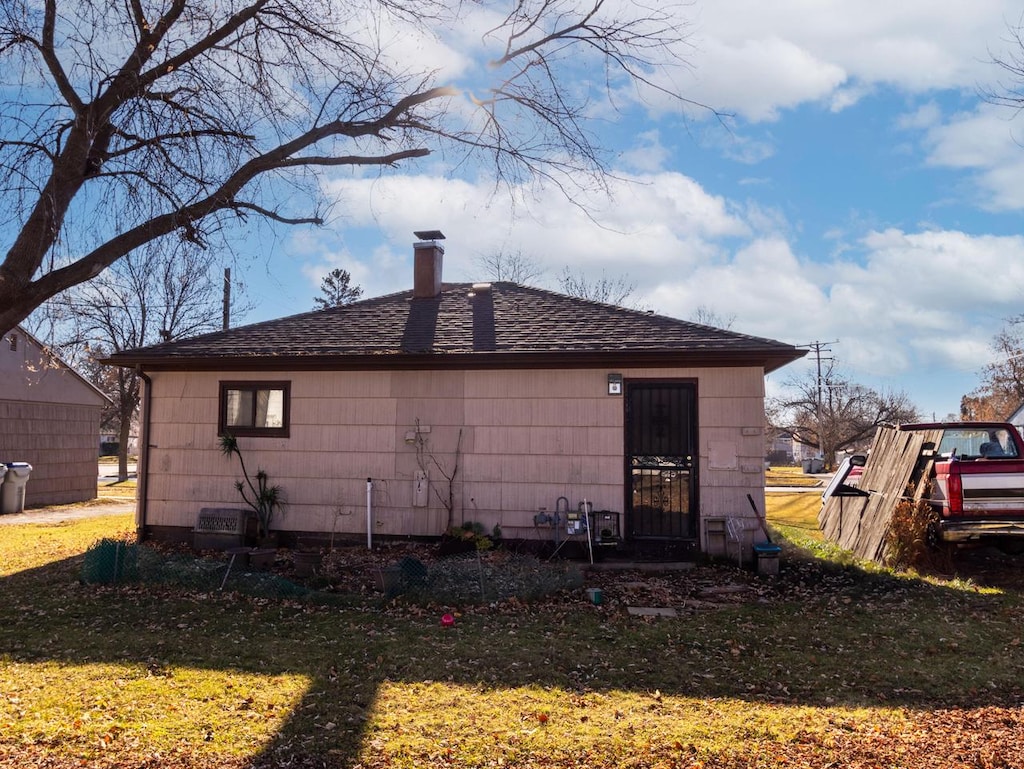 rear view of property featuring a yard