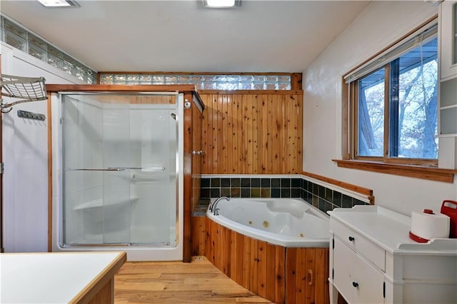 bathroom with wood-type flooring, vanity, and shower with separate bathtub