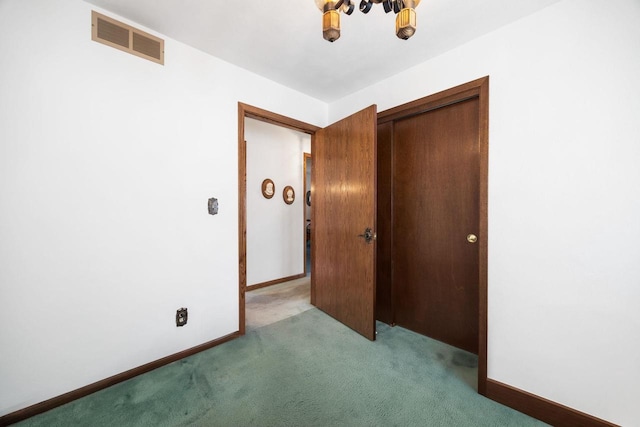 unfurnished bedroom featuring light colored carpet and a closet