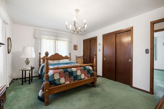 carpeted bedroom with a chandelier and two closets