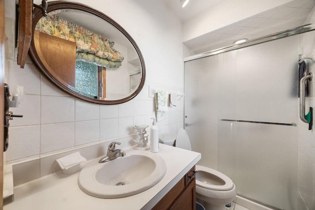 bathroom with toilet, vanity, tile walls, and walk in shower