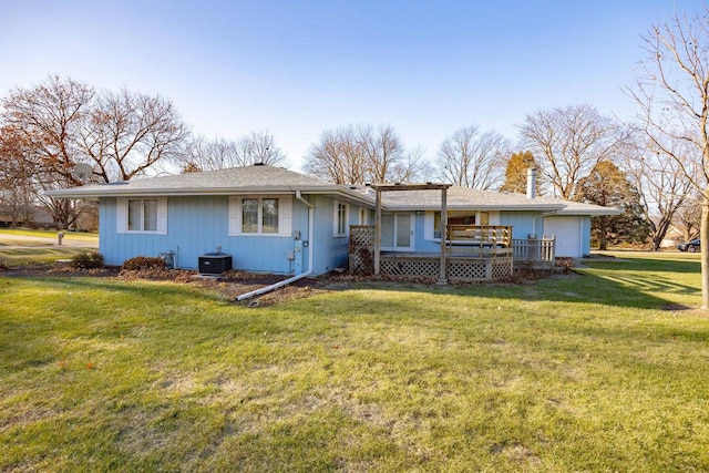 back of property featuring a yard, a deck, and a garage