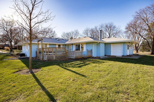 back of house featuring a yard, a garage, and a deck