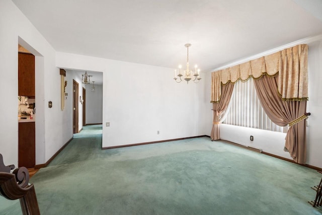 unfurnished room featuring carpet and a notable chandelier