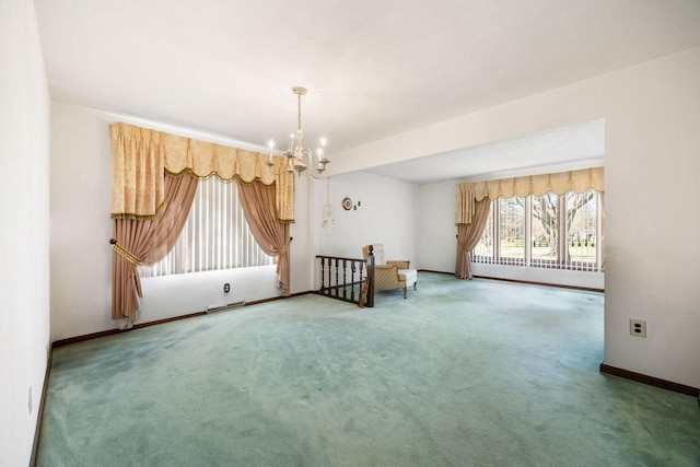 carpeted spare room with a chandelier