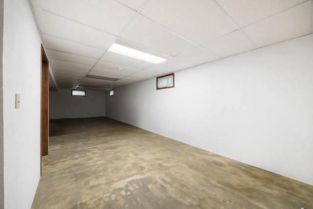 basement with a drop ceiling and plenty of natural light