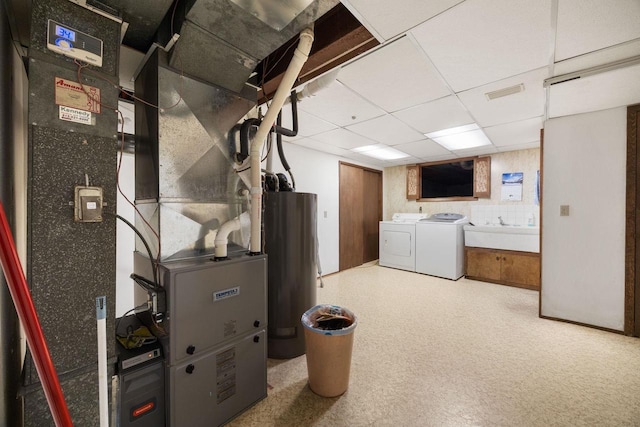 utility room with washing machine and dryer, sink, and water heater