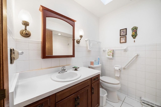 bathroom featuring tile patterned flooring, vanity, toilet, and tile walls