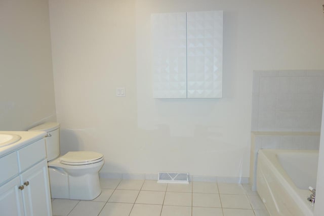 bathroom featuring toilet, vanity, tile patterned floors, and a bathtub