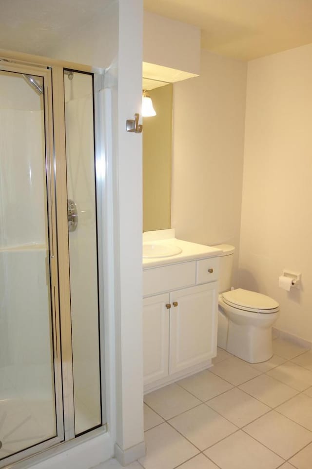 bathroom featuring tile patterned floors, vanity, an enclosed shower, and toilet