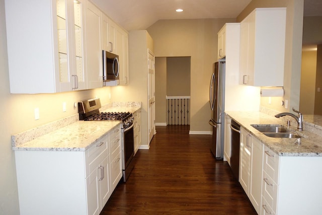 kitchen featuring appliances with stainless steel finishes, dark hardwood / wood-style flooring, light stone counters, sink, and white cabinets