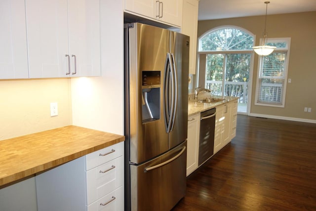 kitchen with dark hardwood / wood-style flooring, stainless steel appliances, sink, white cabinets, and hanging light fixtures