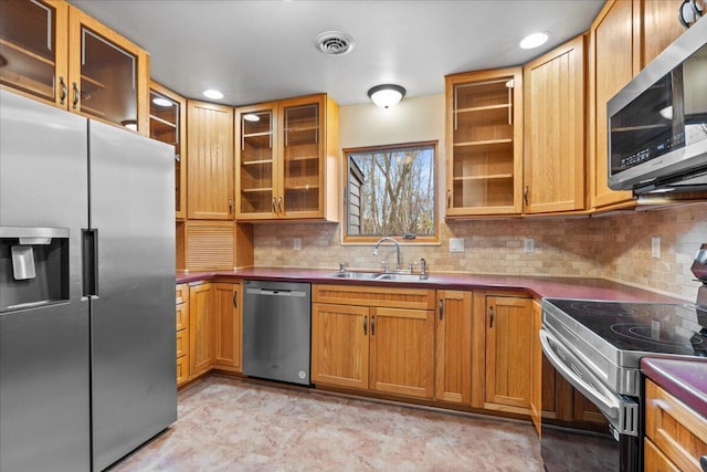 kitchen with appliances with stainless steel finishes, backsplash, and sink