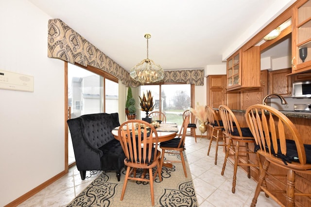 tiled dining space featuring sink and an inviting chandelier