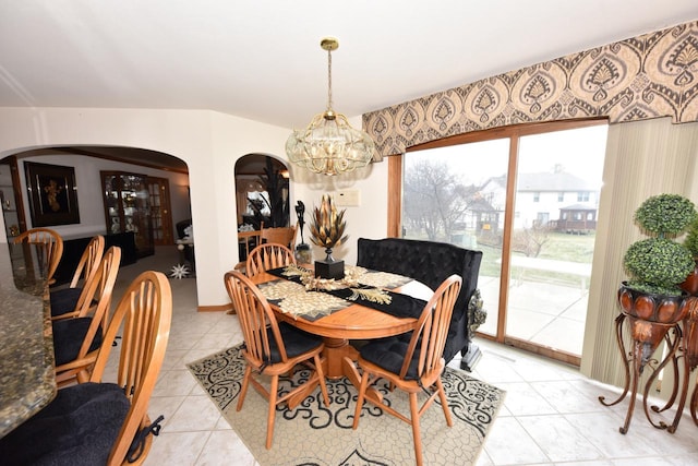 dining area featuring light tile patterned flooring and a notable chandelier