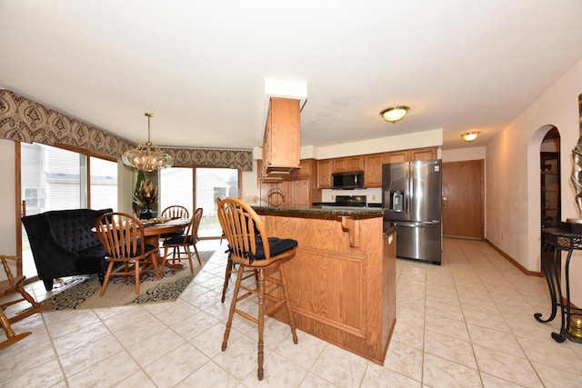 kitchen featuring hanging light fixtures, stainless steel fridge with ice dispenser, a notable chandelier, light tile patterned floors, and range