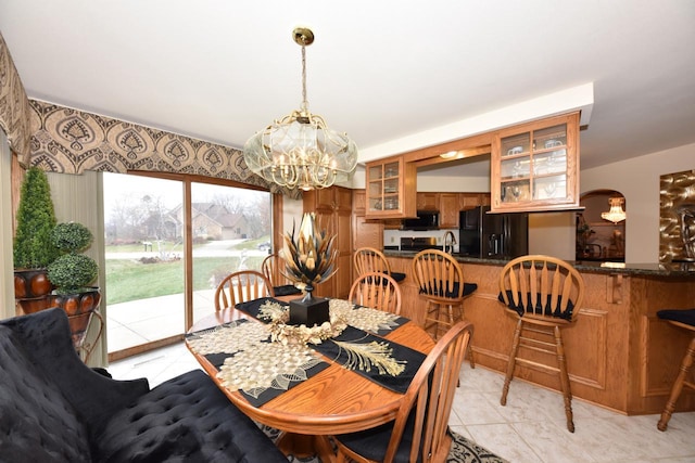 dining room featuring light tile patterned floors, sink, and an inviting chandelier