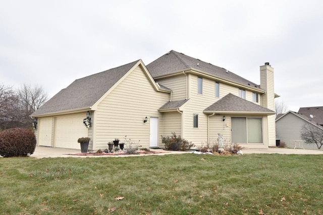 back of house with a yard and a garage