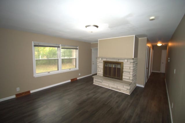 unfurnished living room with a fireplace and dark wood-type flooring